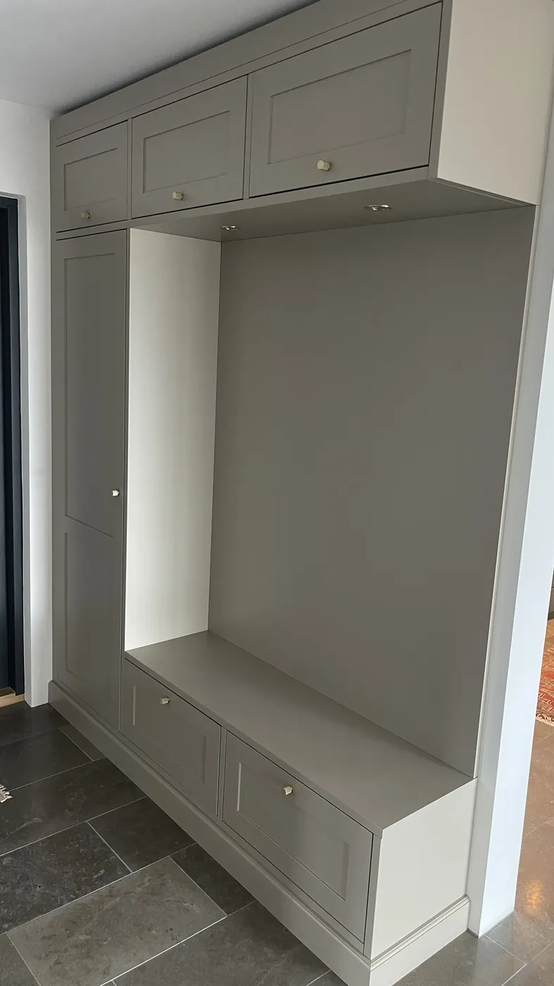 Platsbyggd hallmöbel i grågrönt med sittbänk, lådor, högskåp och överskåp